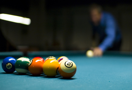 Man breaking, first shot of pool game.